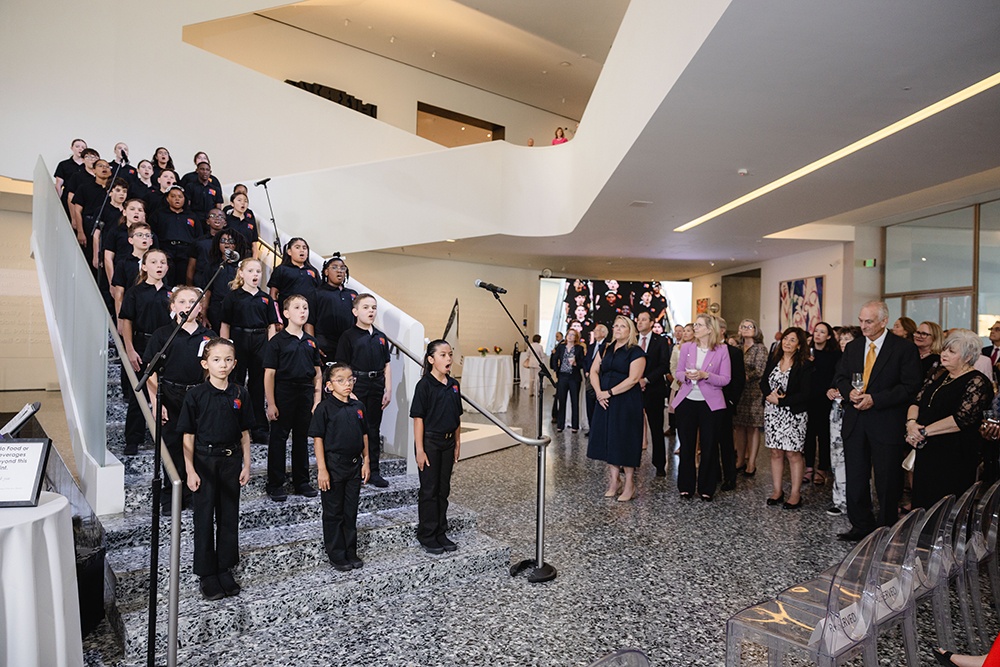 A large group of children singing before an audience.