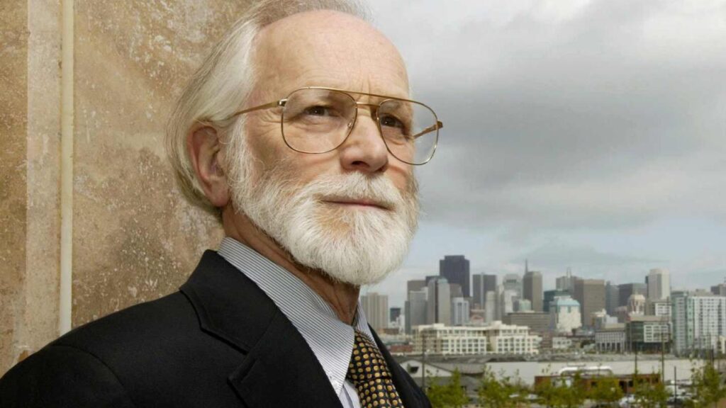 Bishop poses with the background of a campus in the far distance.