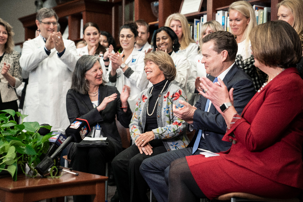 Karen is applauded by a group of people. 