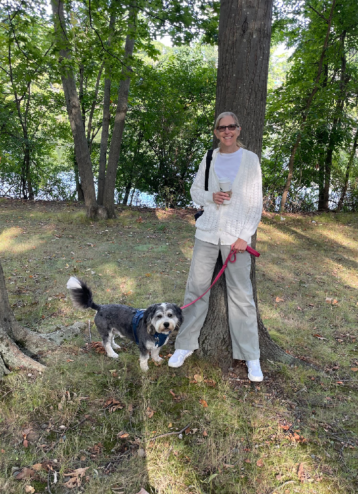 Maura, smiling, and Harry on a walk in a wooded park. 