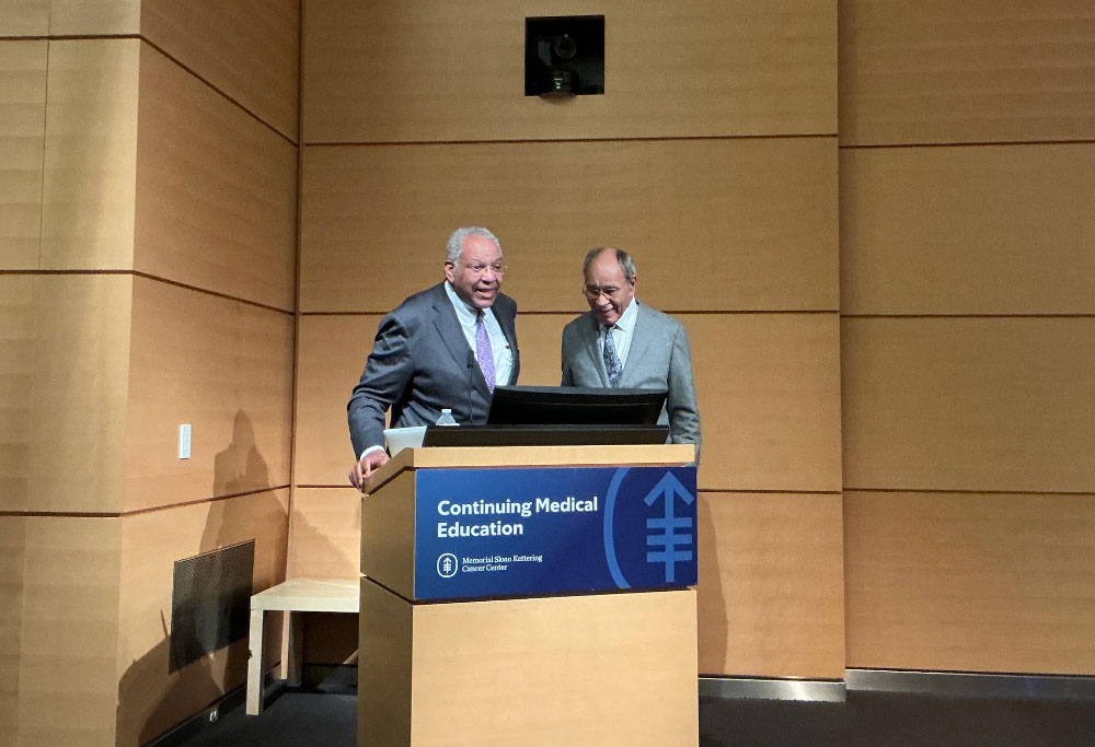 Brawley and Freeman stand behind a podium with a sign that reads, "Continuing Medical Education" and bears the MSKCC logo.