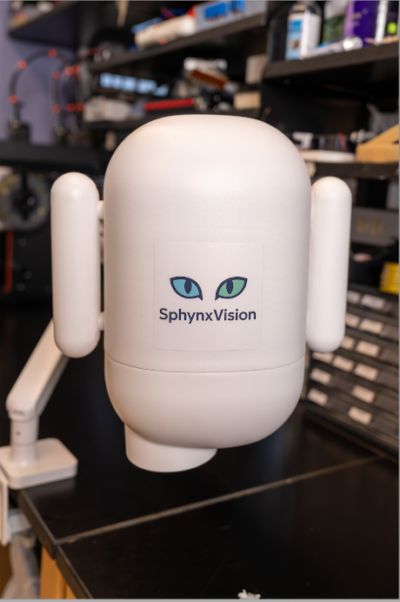 The SphynxVision logo of blue and green cat eyes on a rounded, white imaging device on a swing arm.
