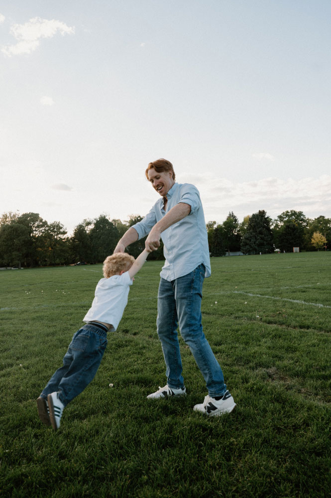 Herzer swings his young son by his arms.